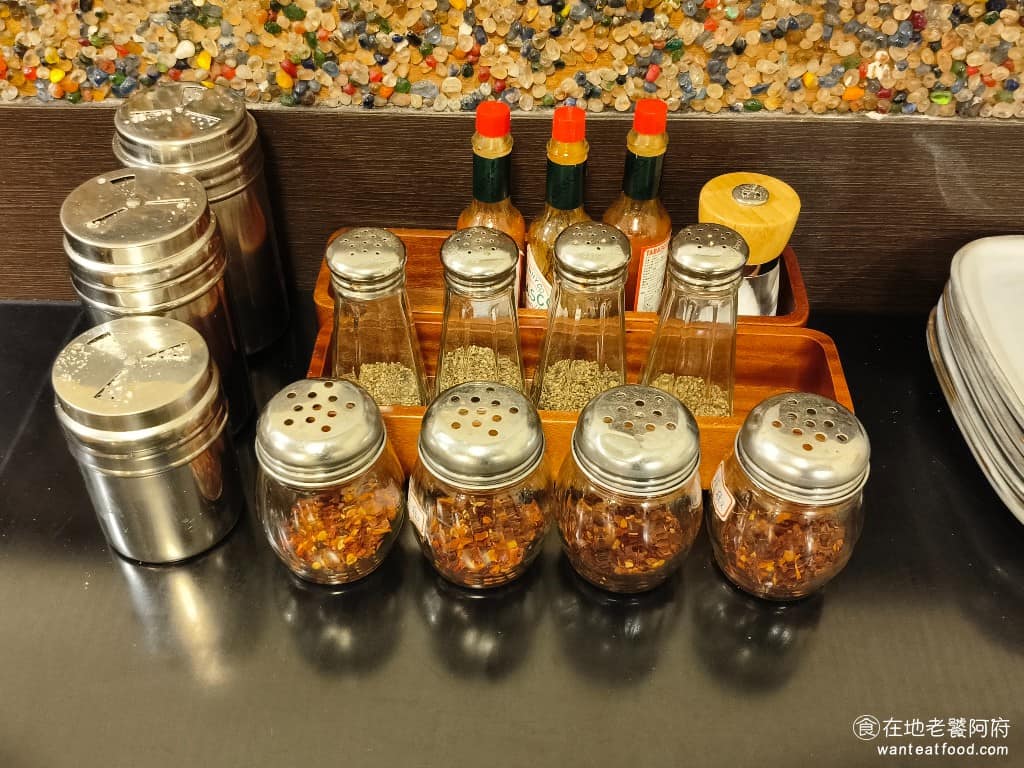 布克湖義式坊 布克湖義式坊菜單 布克湖義式坊推薦 內湖區美食 內湖美食 文德站美食 義式料理 義大利麵 桌上放著一些調味料,有提供辣椒粉、胡椒粉、鹽巴和辣椒醬。 @在地老饕阿府